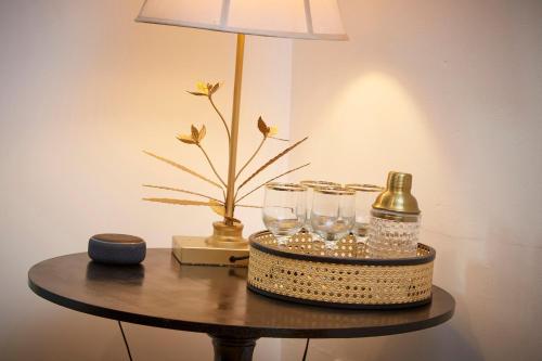 a table with a lamp and a bottle and glasses at Stylish and cosy home-from-home in Hessle