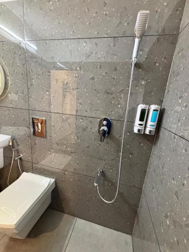 a bathroom with a shower with a toilet at Vadanapilly Beach Villa for 8-10 adults in Irimbranallūr