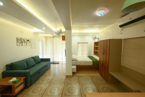 a living room with a couch and a bed at Vadanapilly Beach Villa for 8-10 adults in Irimbranallūr