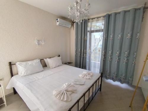 Un dormitorio con una gran cama blanca y una ventana. en Home Shekvetili House, en Shekhvetili