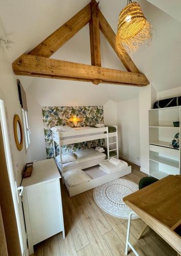 a room with a ceiling with beams and a table at Le Chalet du Parc - Maison de charme Proche Paris in Saint-Gratien