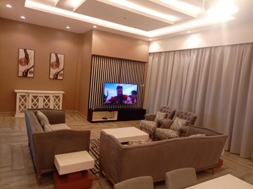 a living room with couches and a flat screen tv at DAVE's LIVING in Kampala