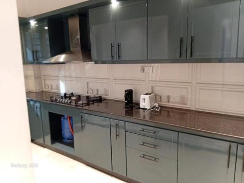 a kitchen with gray and white cabinets and a counter top at Blue Horizon Apartments in Trincomalee