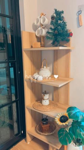 a wooden shelf with cups and a teapot on it at Cana Garden House 1 โฮมสเตย์ in Ban Khok