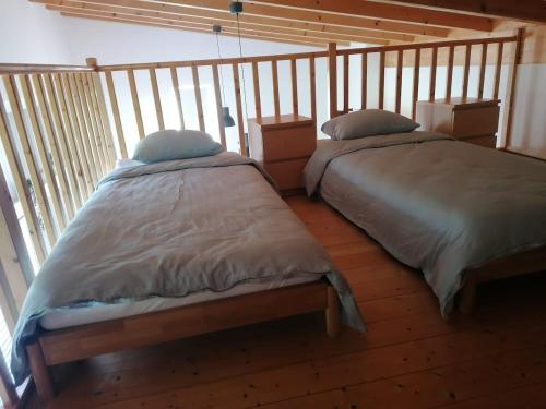 twee bedden naast elkaar in een kamer bij Loft lumineux et confortable in Grimisuat