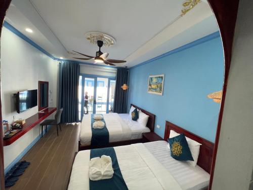 a hotel room with two beds and a ceiling fan at Sadakham Hotel in Luang Prabang