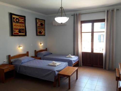 a bedroom with two beds and a window at Makelli Budget Studio B4 in Mesochórion