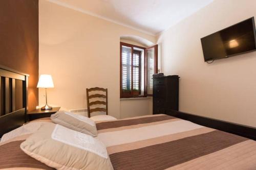 a bedroom with two beds and a flat screen tv at Hostel Kvarner in Rijeka