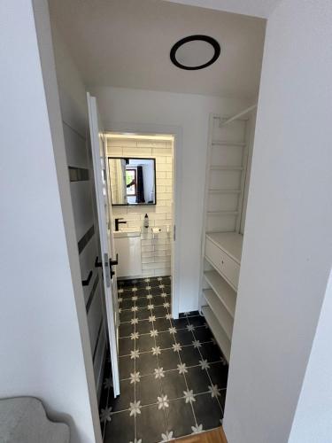 a hallway with a room with white walls and a black and white floor at Naturální vinařství Tomáš Křížek, Penzion Dvorek in Dolní Dunajovice