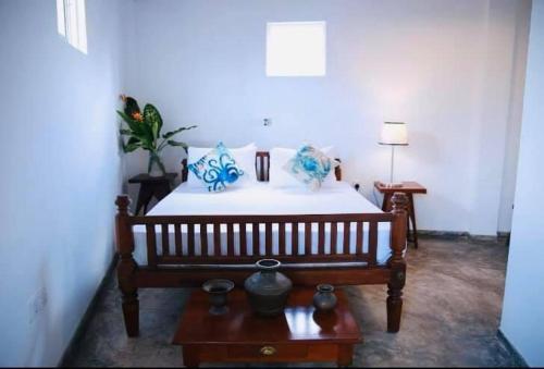 a bedroom with a bed with blue and white pillows at Out Of Rupeace Home Galle in Galle