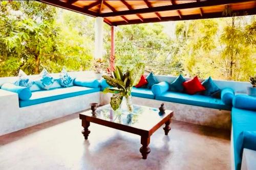 a living room with blue couches and a coffee table at Out Of Rupeace Home Galle in Galle
