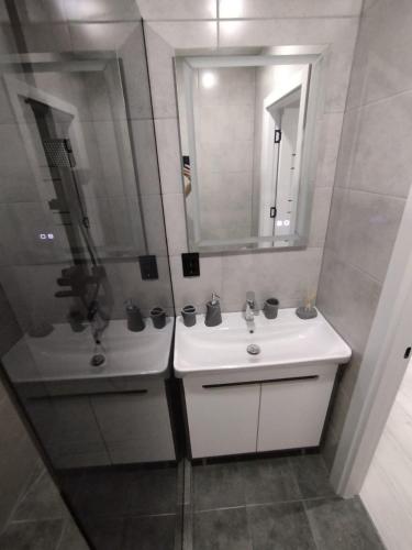 a white bathroom with a sink and a mirror at Comfort MD in Chişinău