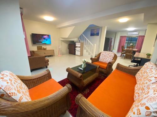a living room with a couch and chairs and a tv at Kata beach Townhouse BL2 in Kata Beach