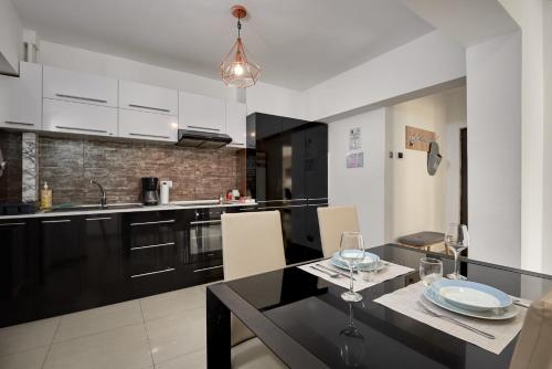 a kitchen with a dining table and a black counter top at Konstanzer Stefan 15 - 3 camere, bucaterie, aer conditionat, masina de spalat in Iaşi
