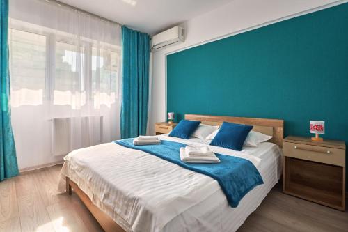 a bedroom with a large bed with blue walls at Konstanzer Stefan 15 - 3 camere, bucaterie, aer conditionat, masina de spalat in Iaşi