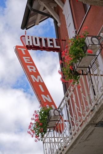a hotel sign on the side of a building with flowers at Quai de l'Ours in Orsières