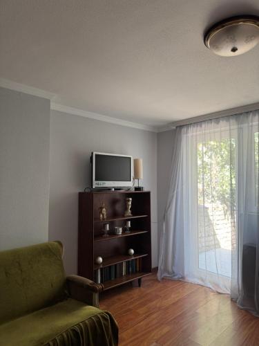 a living room with a tv and a couch and a window at AN Guest house in Tsinandali