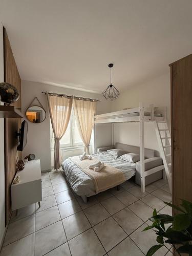 a bedroom with a white bunk bed and a window at T1 bis proche Techn'hom in Belfort