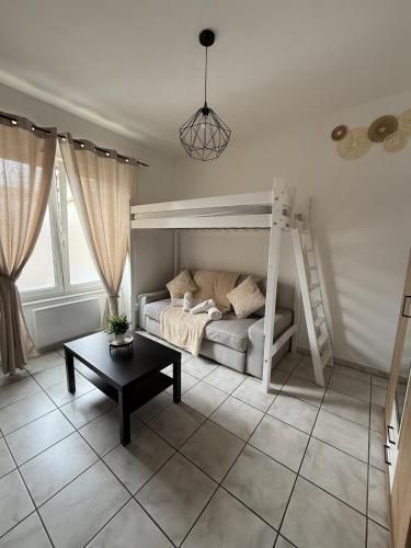 a bedroom with a bunk bed and a table at T1 bis proche Techn'hom in Belfort