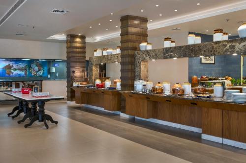a restaurant with a buffet line with food at Radisson Blu Resort, Goa in Cavelossim