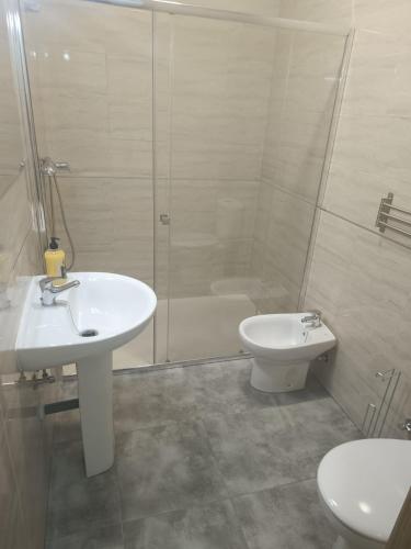 a bathroom with a sink and a shower and a toilet at Apartamentos Turísticos Atalaya in Minas de Ríotinto