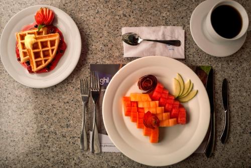 a table with two plates of food and a cup of coffee at GHL Hotel Grand Villavicencio in Villavicencio