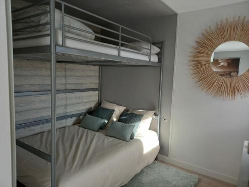een slaapkamer met een stapelbed en een spiegel bij Entre mer et golf in Moliets-et-Maa