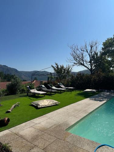 a yard with a swimming pool with boats on the grass at Casa Ermida in Pincães