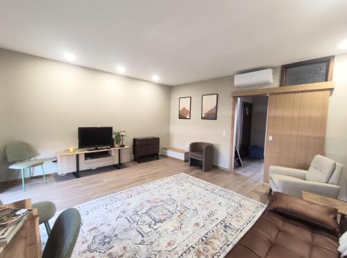 a living room with a couch and a tv and a table at SOL & SAL T2 Matosinhos in Matosinhos