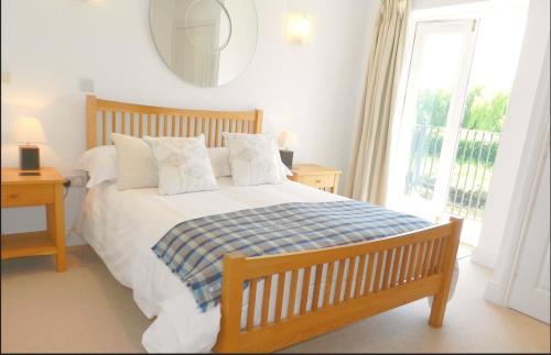 a bedroom with a bed and a window at River Cottage, Arundel Riverside, Just Steps from the Historic Town in Arundel