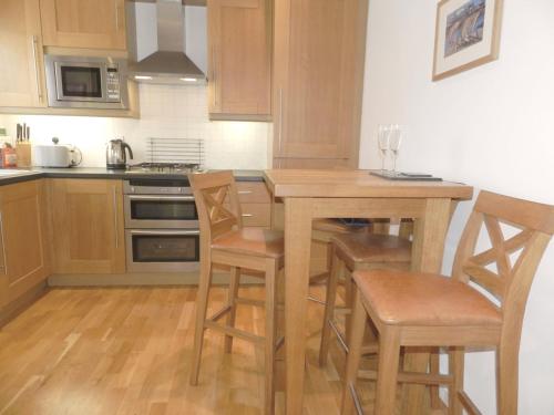 a kitchen with a wooden table and chairs at River Cottage, Arundel Riverside, Just Steps from the Historic Town in Arundel