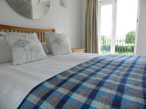 a bedroom with a bed with a large window at River Cottage, Arundel Riverside, Just Steps from the Historic Town in Arundel
