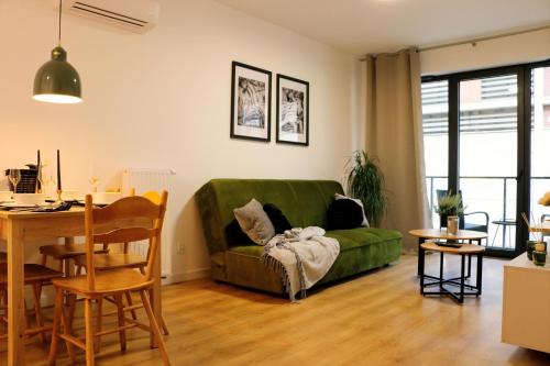 a living room with a green couch and a table at Justinrent PALATIUM 13 in Legnica