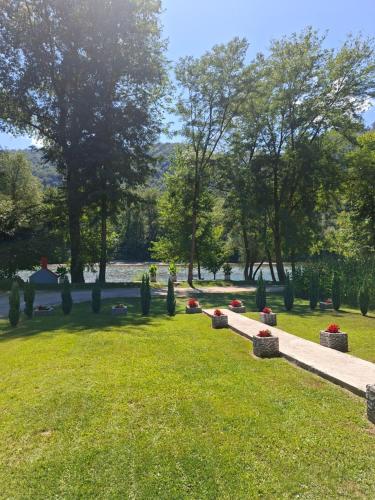 a park with a cemetery and a body of water at Drinski sjaj in Ljubovija