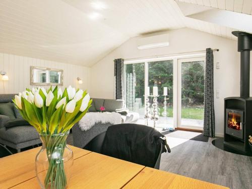 a living room with a vase of flowers on a table at 5 star holiday home in Væggerløse in Bøtø By