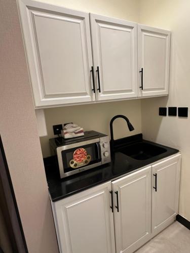 a kitchen counter with a microwave and a sink at استديو رواق in Riyadh