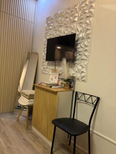 a room with a desk with a chair and a television at The Zion Homestay in Olongapo