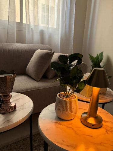 a living room with two tables with a lamp and a couch at diva suite نزل in Hail
