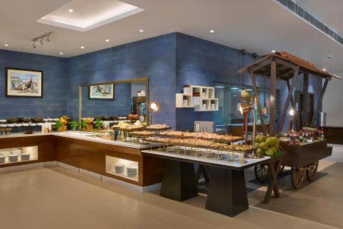 a bakery with blue walls and a counter with food at Radisson Blu Resort, Goa in Cavelossim