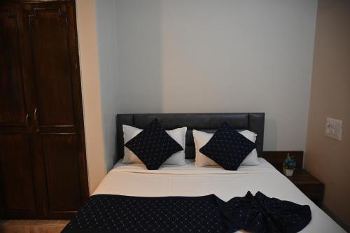 a bedroom with a bed with black and white pillows at Surya service apartments in Jāmb