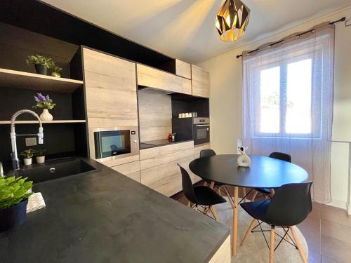 a kitchen with a table and chairs and a television at Superbe T3 à 15 min de Lyon in Pierre-Bénite