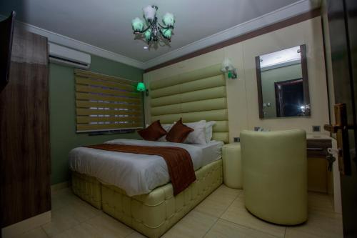 a hotel room with a bed and a mirror at Doreen Grand Hotel and suites in Lagos