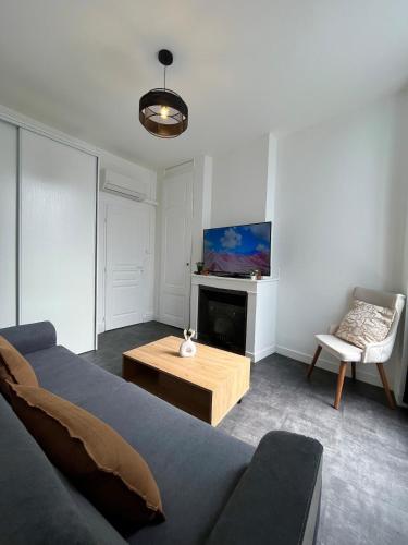 a living room with a couch and a coffee table at Superbe T3 à 15 min de Lyon in Pierre-Bénite