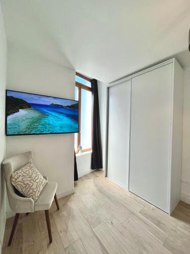 a white room with a sliding door and a chair at Superbe T3 à 15 min de Lyon in Pierre-Bénite