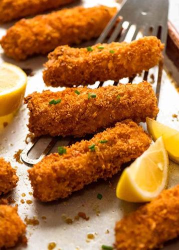 a bunch of fried food with a fork and lemon slices at DAVE's LIVING in Kampala