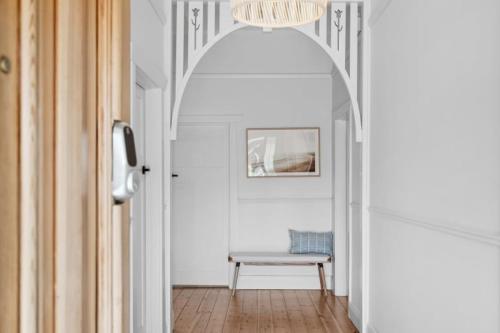 a hallway with a chair and a chandelier at Glenelg Getaway in Glenelg