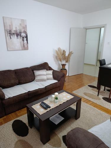 a living room with a couch and a coffee table at Sirmijum Hause II in Sremska Mitrovica