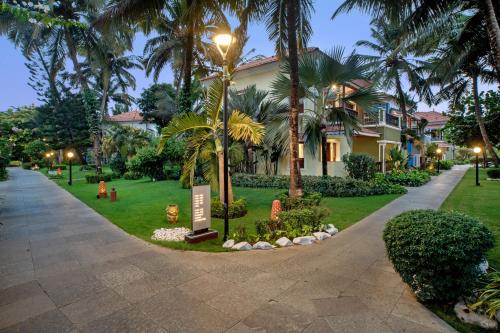 a street light in front of a house with palm trees at Radisson Blu Resort, Goa in Cavelossim