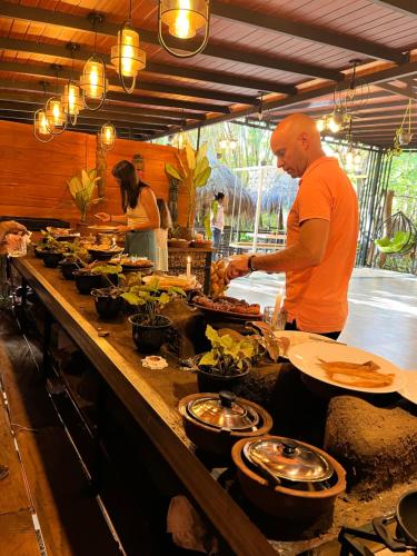 a man preparing food in a restaurant kitchen at Habarana Tree House Ambasewana Resort in Habarana