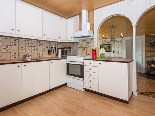 a large kitchen with white cabinets and a sink at 6 person holiday home in Toftlund in Toftlund